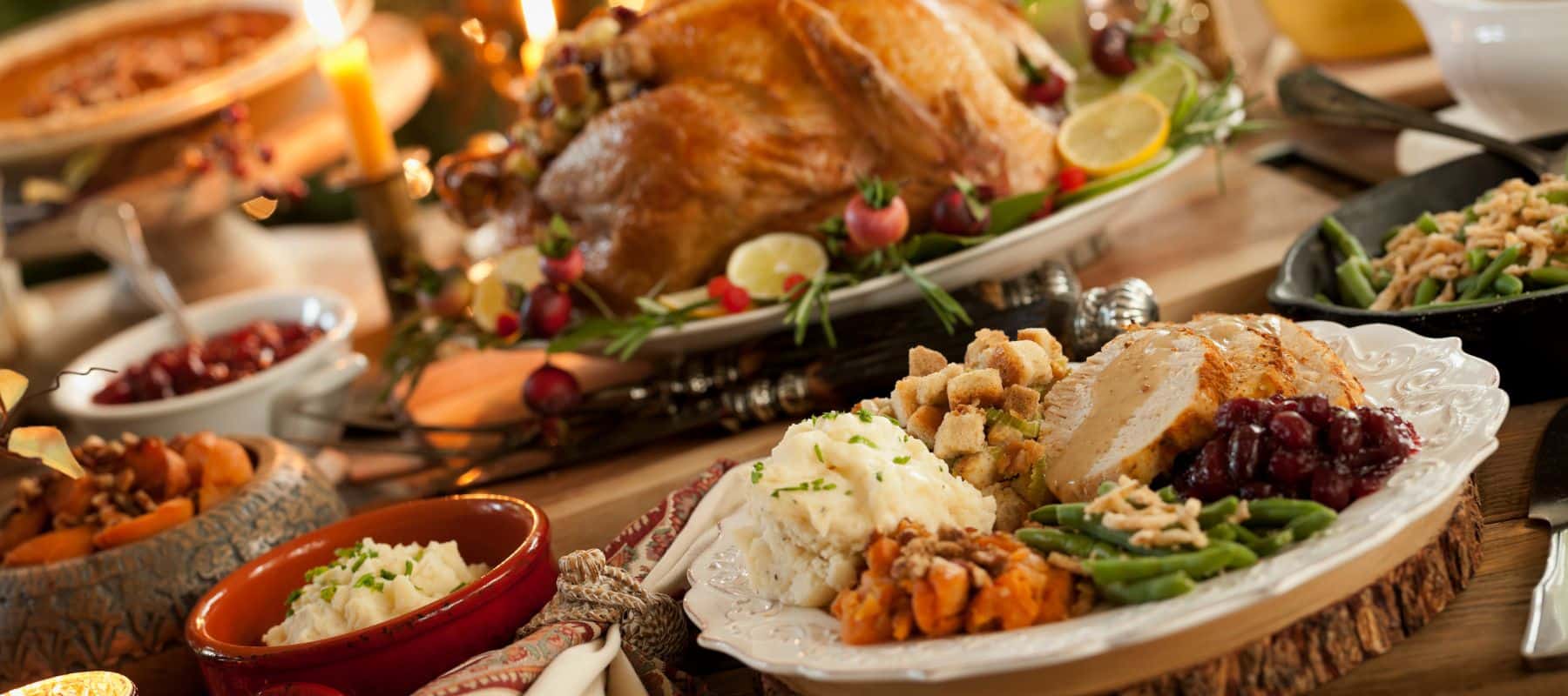 Traditional Thanksgiving feast with roasted turkey, mashed potatoes, stuffing, green beans, and cranberry sauce